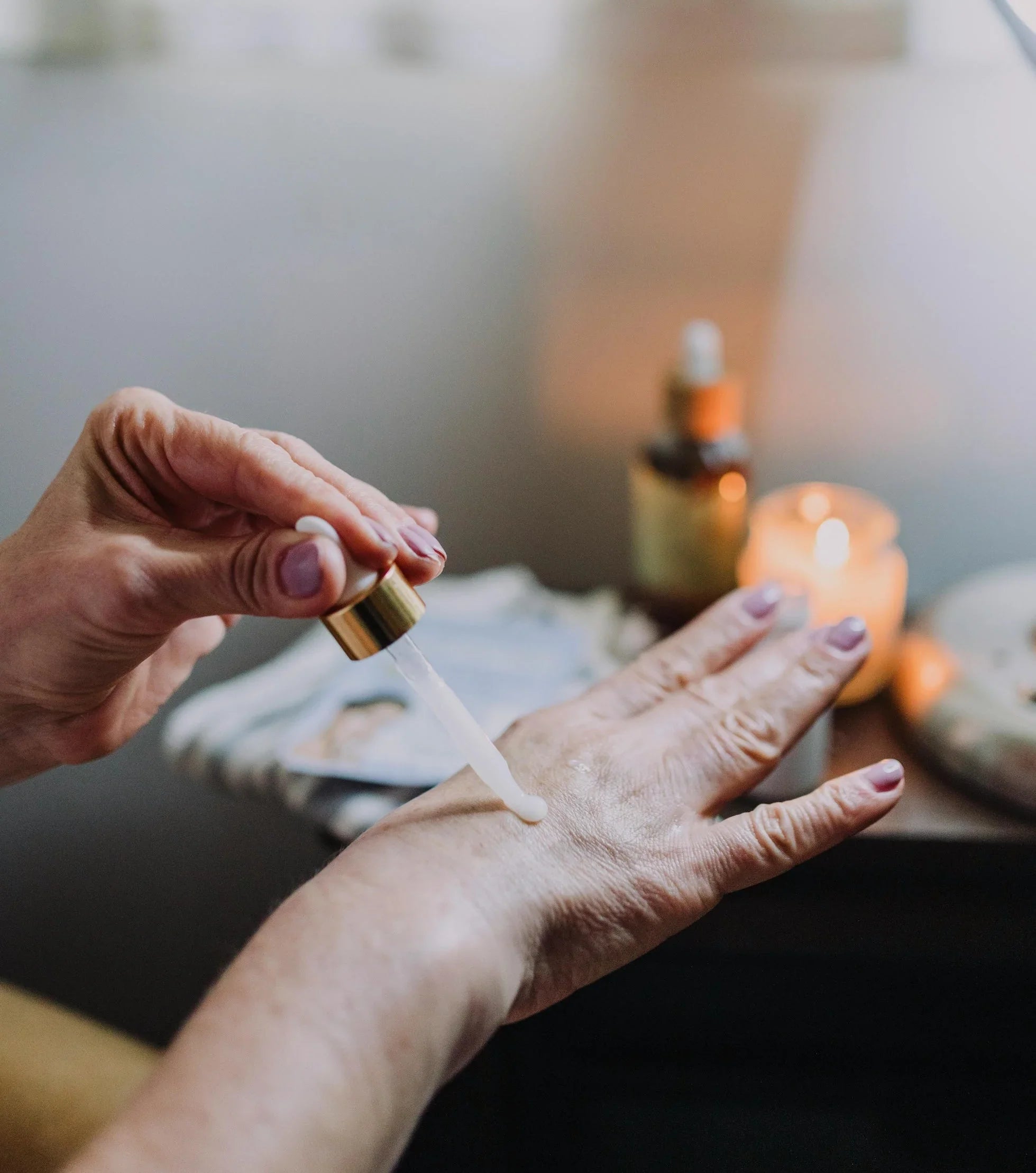 Hand applying serum on wrinkled other hand