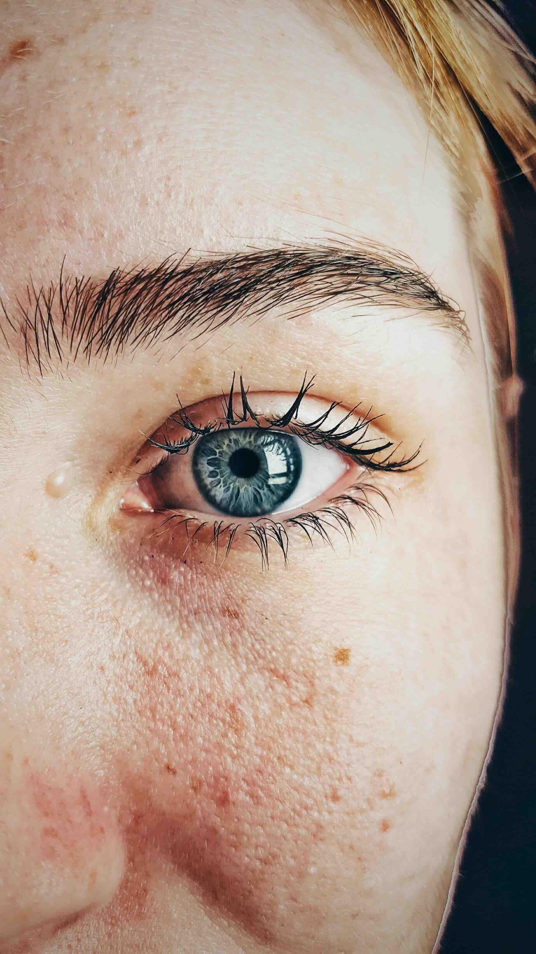 Front profile of right side woman's face with blue eye 