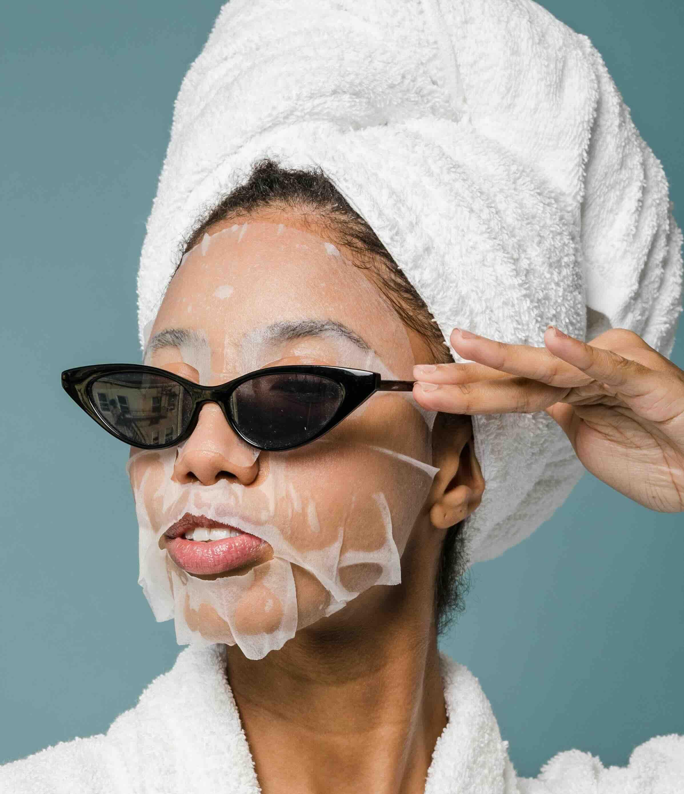 Woman with sheet mask and glasses on